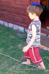  enfant en équilibre avec un pouf sur la tête 